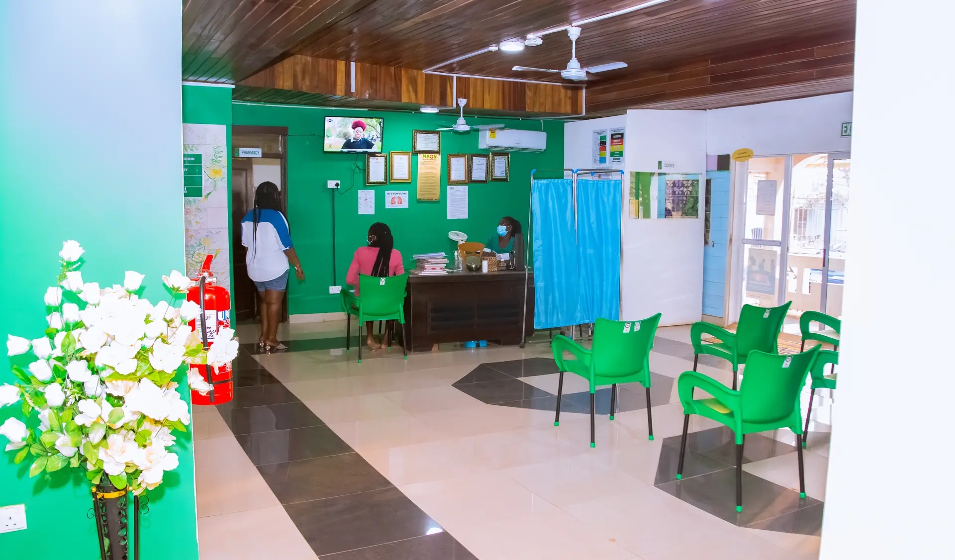 The bright green MAON reception and waiting area, with the front desk and rows of chairs.